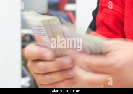 Berechnung des Gewinns. Kurzer Schuss eines Geschäftsmannes, der Geld zählt. Stockfoto