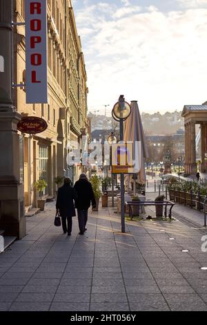 Stuttgart, 06. Januar 2022: Älteres Paar, das gemeinsam durch die Stadt läuft. Ältere Bürger in schwarzer Kleidung Schaufenster einkaufen. Rückansicht. Stockfoto