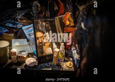 Bangkok, Thailand. 25.. Februar 2022. Die thailändische Drag Queen Angele Anang bringt ihr Gesicht mit einem Foundation Make-up auf, bevor sie als Beyoncé in einer lokalen Bar in Bangkok auftrat.Thai Drag Queens bereiten sich vor einer Show in einer lokalen Bar in Bangkok vor. Obwohl Thailand im Rahmen seines „Test and Go“-Programms ohne Quarantäne die Anforderungen an Touristen gelockert hat, dürfen das Nachtleben und die Unterhaltung trotz des aktuellen Anstiegs der COVID-19-Infektionen, mit durchschnittlich über 20.000 gemeldeten Fällen pro Tag, fortgesetzt werden. Kredit: SOPA Images Limited/Alamy Live Nachrichten Stockfoto