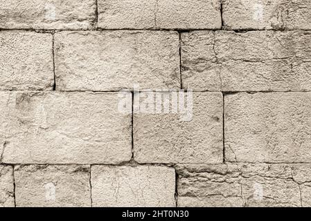 Alte, graue, rissige Steinmauer draußen Stockfoto