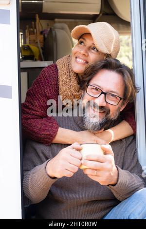 Portrait von Mann und Frau reifen Alter lächeln und Spaß und Glück auf dem Wohnmobil sitzen gemütliche alternative Haustür. Ein paar Touristen-Enjo Stockfoto