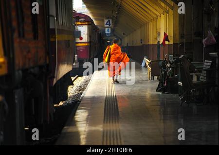 Ein Pendlermönch geht bei seiner Ankunft an der Hau Lumpong Station in Bangkok zum Ausgang. Stockfoto