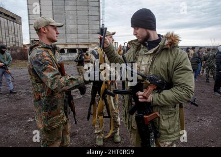Non Exclusive: SIURTE, UKRAINE - 19. FEBRUAR 2022 - Ein Mann in Tarnuniform sammelt Gewehre während einer militärischen Übung für Zivilisten, die b durchgeführt wurde Stockfoto