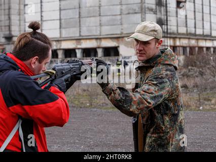 Non Exclusive: SIURTE, UKRAINE - 19. FEBRUAR 2022 - ein Instruktor unterrichtet ein Mädchen während einer militärischen Übung in der stehenden Position Stockfoto