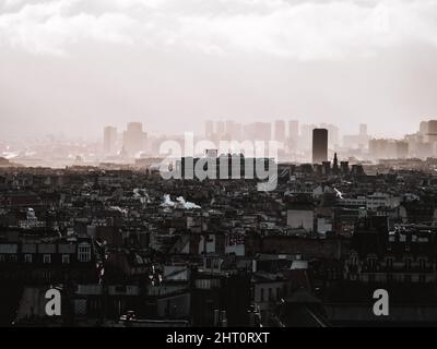 Monochrome Langzeitbelichtung der Pariser Stadtlandschaft mit hohen Gebäuden im nebligen Hintergrund, Frankreich Stockfoto