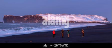 Panorama der Touristen auf Reynisfjara Black Sand Beach bei Sonnenaufgang, in der Nähe des Dorfes Vík i Myrdal, Südosten Islands Stockfoto