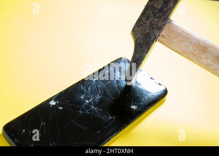 Brechen Sie den Handy-Bildschirm mit einem Hammer Stockfoto