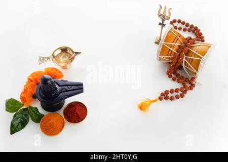 Happy Maha Shivaratri Grußkarte - Shiva Linga geschmückt mit Blumen, Trishula, Damru und Bilva-Blättern. Hinduistisches Fest, das von Shiva Lord gefeiert wird Stockfoto