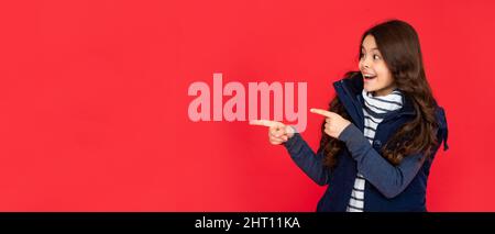Teen Mädchen auf rotem Hintergrund. Porträt des Kindes trägt warme Kleidung. drücken Sie positive Emotion. Stockfoto