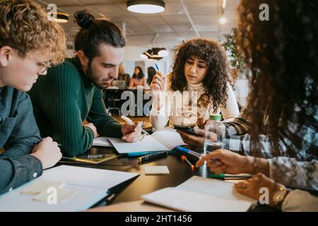 Studenten studieren gemeinsam am Tisch in der Cafeteria Stockfoto