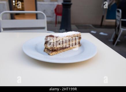 Ein köstliches Stück Schokolade mille-feuille. Auf einem Tisch in einer Cafeteria, draußen. Stockfoto