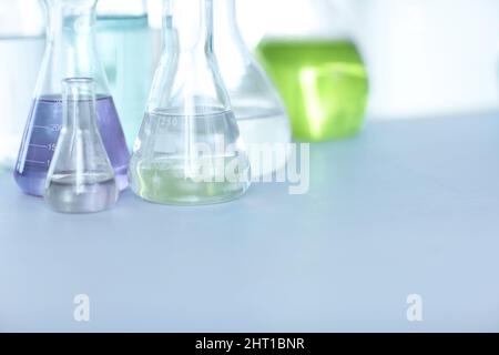 Chemische Verbindungen. Fläschchen gefüllt mit farbenfroher Flüssigkeit auf einem Tisch in einem Labor. Stockfoto