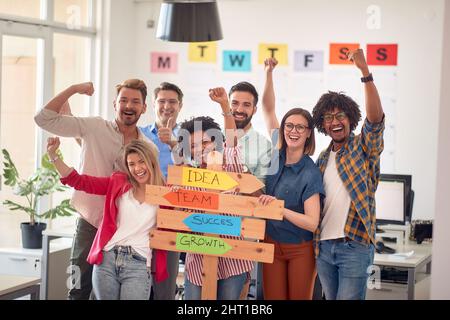 Eine Gruppe von glücklichen Büromitarbeitern posiert für ein Foto in einer angenehmen Atmosphäre im Büro. Mitarbeiter, Job, Büro Stockfoto