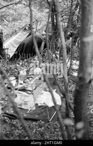 Harry Roberts wollte im Zusammenhang mit der Erschießung von drei Londoner Polizisten wurde heute in einem Wald bei Bishops Stortford in Herts wieder aufgenommen. Roberts, der seit mehr als drei Monaten gesucht wird, gab ohne Probleme der Polizei sgt Peter Smith nach. In einem getarnten Zelt am Rande von Thorley Wood entdeckte die Polizei eines der geschickt ausgeklügeltesten Verstecke, die je bekannt waren, wo Roberts in den letzten sechs Wochen gelebt hat. Das Zelt ist 5ft hoch an seinem höchsten Punkt und von einer Plastikfolie getarnt und enthielt eine Fülle von Lebensmitteln und Brennstoffen. Ein Camp-Bett und ein Aluminium-Stuhl wie wir Stockfoto