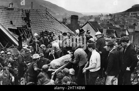 Aberfan 21.. Oktober 1966 nach dem katastrophalen Zusammenbruch einer kollidierenden Beute im walisischen Dorf Aberfan, bei dem 116 Kinder und 28 Erwachsene getötet wurden, wird für einen Moment ein weiterer Leichnam aus der zerrütteten Pantglas Junior School gebracht.die Ereignisse vom Freitag, den 21. Oktober 1966 Tipp Nr. 7, das 500 Meter über dem Dorf Aberfan in der Nähe von Merthyr Tydfil lag, begann um 9,15 Uhr zu rutschen. Es war der letzte Tag vor der Halbzeit an den Pantglas-Schulen unten. Es traf zuerst eine Farm und tötete alle darin. Dann verschlang sie die Pantglas Junior School und tötete 109 Kinder und fünf Lehrer. Onl Stockfoto