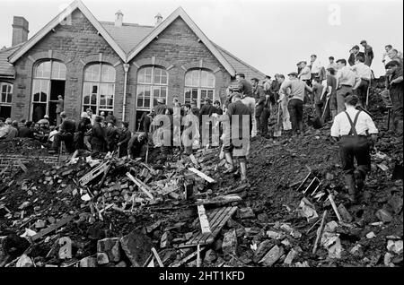 Aberfan, Südwales, um 21.. Oktober 1966 das Bild zeigt den Schlamm und die Verwüstungen, die verursacht wurden, als am 21.. Oktober 1966 die Bergbauschürze hoch über der Stadt herunterkam und die Pantglas Junior School verschlang. Retter, die versuchen, Opfer zu finden und zu helfen, monisten den Schlamm und die Trümmer um den Schulstandort herum. Die Katastrophe von Aberfan war ein katastrophaler Einsturz einer kollidierenden Beute im walisischen Dorf Aberfan, in der Nähe von Merthyr Tydfil. Es wurde durch eine Ansammlung von Wasser in den angesammelten Felsen und Schiefer verursacht, die plötzlich begann, in Form von Schlamm bergab zu rutschen und verschlang die Stockfoto