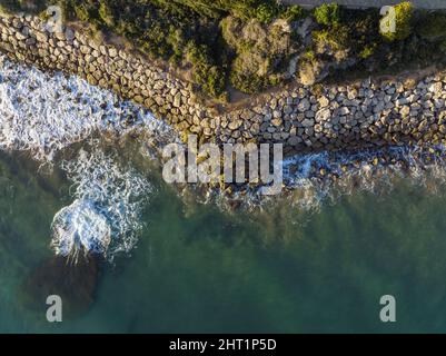 Luftaufnahme des sauberen Wassers des türkisfarbenen Meeres, das nahe der Küste winkt Stockfoto