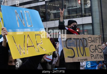 Düsseldorf, Deutschland. 26.. Februar 2022. Die Demonstranten halten Schilder mit den Aufschrift „kein Krieg“ und „Stoppt Swift, Gas, Putin“. Mehrere hundert Menschen demonstrierten auf dem Schadowplatz gegen den Angriff Russlands auf die Ukraine. Quelle: Roberto Pfeil/dpa/Alamy Live News Stockfoto