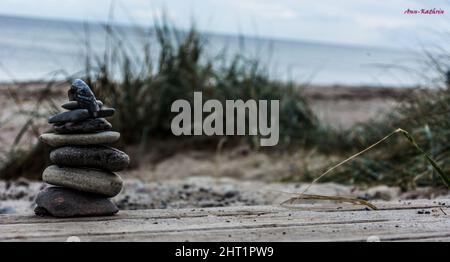 Nahaufnahme einer Cairn am Sandstrand gegen den bewölkten Himmel im Sommer Stockfoto