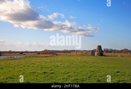 Ein Blick auf das zerstörte St. Benet's Abbey Gatehouse und Drainage Mill am Fluss Bure auf den Norfolk Broads in Horning, Norfolk, England, Großbritannien. Stockfoto