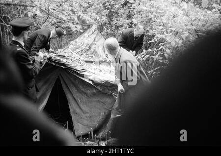 Harry Roberts wollte im Zusammenhang mit der Erschießung von drei Londoner Polizisten wurde heute in einem Wald bei Bishops Stortford in Herts wieder aufgenommen. Roberts, der seit mehr als drei Monaten gesucht wird, gab ohne Probleme der Polizei sgt Peter Smith nach. In einem getarnten Zelt am Rande von Thorley Wood entdeckte die Polizei eines der geschickt ausgeklügeltesten Verstecke, die je bekannt waren, wo Roberts in den letzten sechs Wochen gelebt hat. Das Zelt ist 5ft hoch an seinem höchsten Punkt und von einer Plastikfolie getarnt und enthielt eine Fülle von Lebensmitteln und Brennstoffen. Ein Camp-Bett und ein Aluminium-Stuhl wie wir Stockfoto