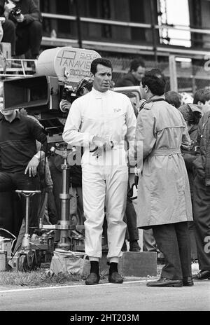 Dreharbeiten zum MGN-Film „Grand Prix“ bei Brands Hatch in Kent im Juli 1966. Schauspieler James Garner ist der amerikanische Grand-Prix-Fahrer Pete Aron, der von seinem Jordan-BRM-Rennteam gefeuert wird und für das japanische Yamura-Team fährt. Im Bild: Während der Dreharbeiten musste James Garner seinen Rennwagen (kein Stunt-Mann) für 1/2 eine Meile rund um Brands Hatch Circuit fahren, während er in Brand war. James hielt kurz nach der Ziellinie an und sprang aus dem Cockpit, als Flammen das Auto umschlingen. Feuerwehrmänner waren bereit, die Flammen zu löschen. James Garner ist während der Dreharbeiten zu diesem Film für £1million versichert. Stockfoto