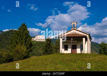 Die Kapelle Chiesa di San Giacomo, CastelBrando, eine mittelalterliche Burg auf einem Dolomitgestein aus Kalkstein, in der Ferne. Stockfoto