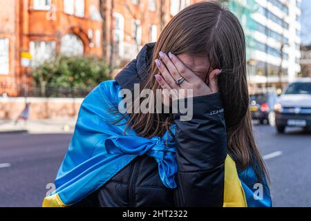 LONDON, GROSSBRITANNIEN. 26. Februar 2022.Eine Frau ist von Emotionen überwältigt während einer Demonstration vor der russischen Botschaft in Kensington Palace Gardens, West London, um gegen die Entscheidung von Wladimir Putin zu protestieren, Anfang dieser Woche gegen die Ukraine einzumarschieren und Solidarität mit dem ukrainischen Volk zu zeigen. Ähnliche Proteste gab es in vielen Städten auf der ganzen Welt. Kredit: amer ghazzal/Alamy Live Nachrichten Stockfoto