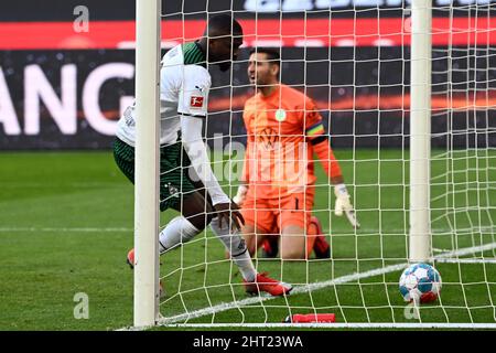 26. Februar 2022, Nordrhein-Westfalen, Mönchengladbach: Fußball: Bundesliga, Borussia Mönchengladbach - VfL Wolfsburg, Matchday 24, Stadion im Borussia-Park. Mönchengladbachs Marcus Thuram (l) holt nach 1:2 den Ball aus dem Tor, Wolfsburg-Torhüter Koen Casteels kniet hinter sich. Foto: Federico Gambarini/dpa - WICHTIGER HINWEIS: Gemäß den Anforderungen der DFL Deutsche Fußball Liga und des DFB Deutscher Fußball-Bund ist es untersagt, im Stadion und/oder vom Spiel aufgenommene Fotos in Form von Sequenzbildern und/oder videoähnl. Phot zu verwenden oder zu verwenden Stockfoto