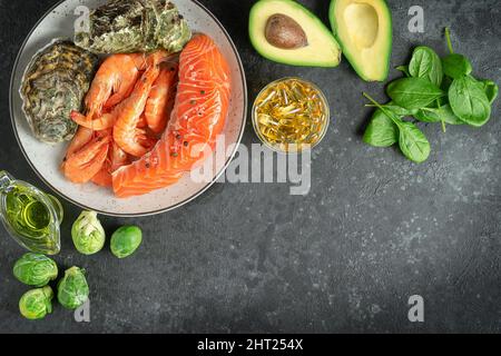 Omega 3 Lebensmittelzusammensetzung auf dunklem Betongrund. Platz kopieren, Draufsicht. Stockfoto