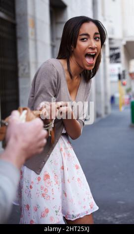 Hilfe, ich bin ausgeraubt. Junge Frau, die ihre Tasche von einem Kriminellen entrissen hat. Stockfoto