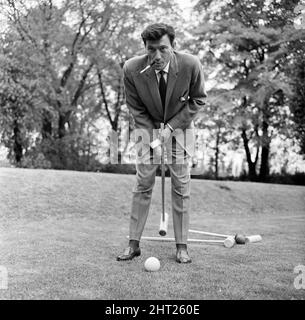 Laurence Harvey spielt auf dem Rasen des Hauses in Priesthorpe Lane, in Bingley, Yorkshire, ein schnelles Krocketspiel, wo heute die Dreharbeiten zu „Life at the Top“ stattfinden. 24. Mai 1965. Stockfoto