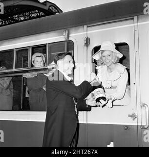 Szenen vor dem Rathaus von Liverpool, als Maureen Martin (Miss Liverpool) an Bord eines Bühnenkutschers zur Lime Street Station ging, um den Merseyside Express nach London zu erreichen, wo sie dem Premierminister den Champagner „Liverpool 66“ und ein Büchlein überreichte. Der Oberbürgermeister, Alderman David Cowley, wird mit Maureen abgebildet, als Bessie Braddock MP durch das Wagenfenster gleist. 3.. März 1966. Stockfoto