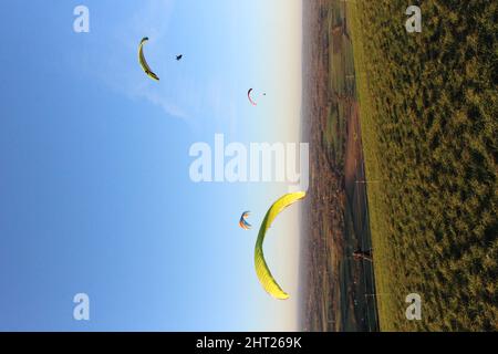 Vertikale Aufnahme der Gleitschirme, die über Devils Dyke fliegen, Großbritannien. Stockfoto