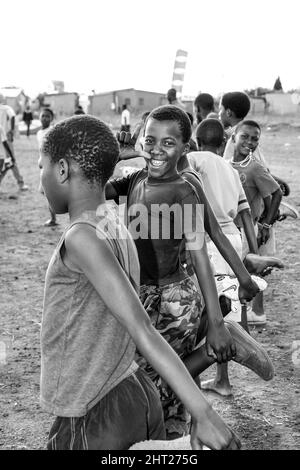 Junge afrikanische Kinder, die Fußball-Aktivitäten auf einem Schulhof durchführen Stockfoto