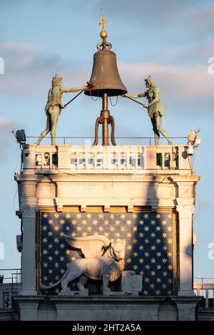 Markusturm oder Torre dell’Orologio in Venedig, Italien, mit Mauren, die auf einer Glocke und einem geflügelten Löwen die Stunde schlagen Stockfoto