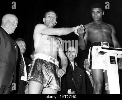 Der amerikanische Weltmeister im Schwergewicht Muhammad Ali, früher bekannt als Cassius Clay, wurde im Odeon Cinema auf dem Leicester Square während der Einwaage für seinen schweren Titelkampf gegen den britischen Herausforderer Henry Cooper (links) im Highbury Stadium, North London, abgebildet. Ali gewann den Kampf in der sechsten Runde, als der Schiedsrichter den Kampf wegen einer tiefen Öffnung über Coopers linkem Auge stoppen musste. 21. Mai 1966. Stockfoto