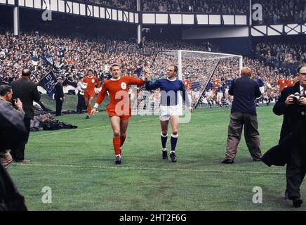 Das 1966 FA Charity Shield Merseyside Derby-Spiel zwischen Liverpool und Everton im Goodison Park. Vor dem Spiel haben Roger Hunt, Alan Ball und Ray Wilson die Weltmeisterschaft, den FA Cup und die Football League Trophy um den Goodison Park geführt. Liverpool gewann das Spiel mit einem Tor von 1 zu 0. Das Bild zeigt: Roger Hunt und Ray Wilson, Mitglieder des siegreichen England-Teams des Sommers, paradieren die WM-Trophäe um das Stadion. 13.. August 1966. Stockfoto