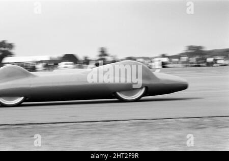 Proteus Bluebird, das Auto, mit dem Donald Campbell den Weltrekord im Automobilbau gebrochen hat, hat nun seinen letzten Lauf mit 5 mph auf der RAF Station, Debden, Essex, 19.. Juni 1966. Campbell sollte dort bei einer Gala einen Demonstrationslauf geben, Doch 5 Tage zuvor wurde das Auto schwer beschädigt, als es mit dem Rennfahrer Peter Bolton an der Steuerung durch einen Holzzaun und eine Hecke mit 100 km/h zerschmetterte, 10ft in der Luft über die Cambridge Chelsford Road segelte und schließlich 200 Meter lang über ein Feld drehte. Stockfoto