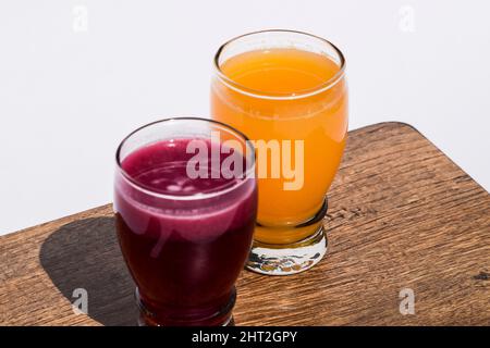 Granatapfelsaft und Orangensaft malta Saft in transparentem Glas auf weißem Hintergrund. Anaar Juice santra ras auf Holzbrett Stockfoto