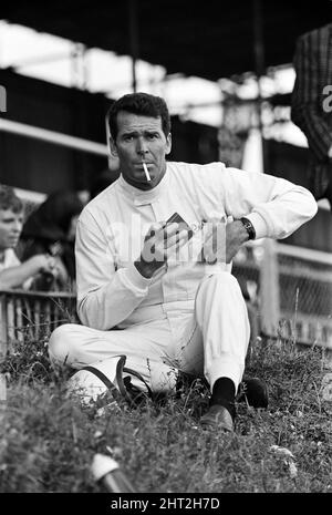 Dreharbeiten zum MGN-Film „Grand Prix“ bei Brands Hatch in Kent im Juli 1966. Schauspieler James Garner ist der amerikanische Grand-Prix-Fahrer Pete Aron, der von seinem Jordan-BRM-Rennteam gefeuert wird und für das japanische Yamura-Team fährt. Im Bild: Während der Dreharbeiten musste James Garner seinen Rennwagen (kein Stunt-Mann) für 1/2 eine Meile rund um Brands Hatch Circuit fahren, während er in Brand war. James hielt kurz nach der Ziellinie an und sprang aus dem Cockpit, als Flammen das Auto umschlingen. Feuerwehrmänner waren bereit, die Flammen zu löschen. James Garner ist während der Dreharbeiten zu diesem Film für £1million versichert. Stockfoto