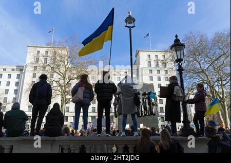 Protest gegen die russische Invasion der Ukraine vor der Downing Street. Demonstranten, die in Silhouette stehen und eine ukrainische Flagge schwenken. London Stockfoto