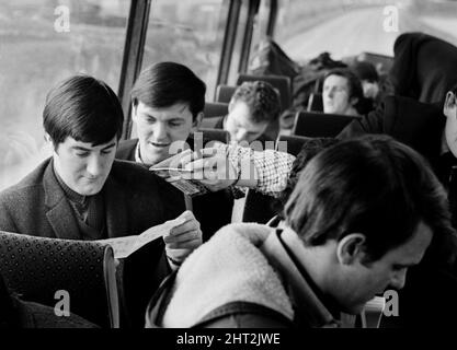 Die Pop-Gruppe The Fourmost auf Tour Musiker Mike Cotton (links) und Les Muscutt machen Flugzeuge, um die Zeit zu vergehen, während sie im Bus am 1965. Februar reisen Stockfoto