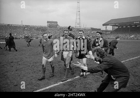 FA Cup Halbfinalspiel in Burnden Park, Bolton.Everton 1 gegen Manchester United 0. Die Spieler Nobby Stiles und Torhüter Harry Gregg von United werden von einem Everton-Fan verhöhnt, als sie nach ihrer Niederlage vom Spielfeld gehen. 23.. April 1966. Stockfoto