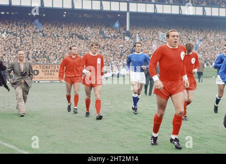 Das 1966 FA Charity Shield Merseyside Derby-Spiel zwischen Liverpool und Everton im Goodison Park. Vor dem Spiel haben Roger Hunt, Alan Ball und Ray Wilson die Weltmeisterschaft, den FA Cup und die Football League Trophy um den Goodison Park geführt. Liverpool gewann das Spiel mit einem Tor von 1 zu 0. Bild zeigt: Liverpool und Everton Spieler auf dem Platz während einer Ehrenrunde mit den drei Trophäen. Rechts ist Ian St. John. 13.. August 1966. Stockfoto