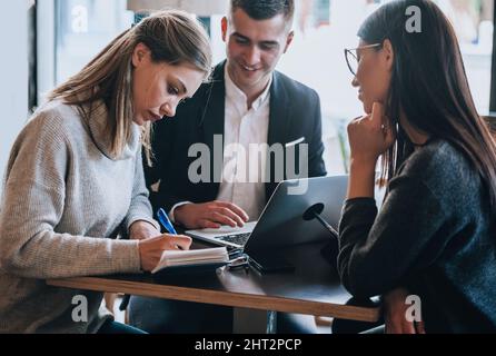 Arbeitskollegen diskutieren während einer Kaffeepause über neue Marketingstrategien Stockfoto