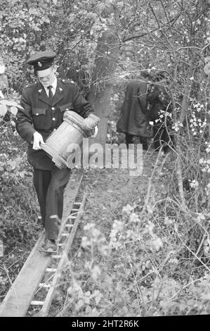 Harry Roberts wollte im Zusammenhang mit der Erschießung von drei Londoner Polizisten wurde heute in einem Wald bei Bishops Stortford in Herts wieder aufgenommen. Roberts, der seit mehr als drei Monaten gesucht wird, gab ohne Probleme der Polizei sgt Peter Smith nach. In einem getarnten Zelt am Rande von Thorley Wood entdeckte die Polizei eines der geschickt ausgeklügeltesten Verstecke, die je bekannt waren, wo Roberts in den letzten sechs Wochen gelebt hat. Das Zelt ist 5ft hoch an seinem höchsten Punkt und von einer Plastikfolie getarnt und enthielt eine Fülle von Lebensmitteln und Brennstoffen. Ein Camp-Bett und ein Aluminium-Stuhl wie wir Stockfoto