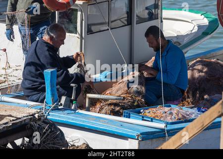 Side; Türkei – Februar 02 2022: Fischer auf einem Boot wickeln das Fischernetz ab Stockfoto