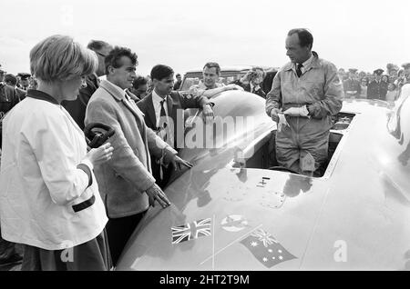 Proteus Bluebird, das Auto, mit dem Donald Campbell den Weltrekord im Automobilbau gebrochen hat, hat nun seinen letzten Lauf mit 5 mph auf der RAF Station, Debden, Essex, 19.. Juni 1966. Campbell sollte dort bei einer Gala einen Demonstrationslauf geben, Doch 5 Tage zuvor wurde das Auto schwer beschädigt, als es mit dem Rennfahrer Peter Bolton an der Steuerung durch einen Holzzaun und eine Hecke mit 100 km/h zerschmetterte, 10ft in der Luft über die Cambridge Chelsford Road segelte und schließlich 200 Meter lang über ein Feld drehte. Ebenfalls abgebildet, Frau Tonia Campbell. Stockfoto