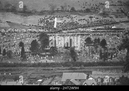 Aberfan - 27.. Oktober 1966 das riesige Kreuz von Kränzen auf dem Aberfan-Friedhof am Hang, während die Beerdigungen stattfinden. Die Katastrophe von Aberfan war ein katastrophaler Einsturz einer kollidierenden Beute im walisischen Dorf Aberfan, in der Nähe von Merthyr Tydfil. Er wurde durch eine Ansammlung von Wasser im angesammelten Fels und Schiefer verursacht, die plötzlich in Form von Schlamm bergab zu rutschen begann und am 21.. Oktober 1966 die Pantglas Junior School darunter verschlang und 116 Kinder und 28 Erwachsene tötete. Das ursprüngliche Schulgelände ist heute ein Gedenkgarten. Aufgenommen am 27.. Oktober 1966The Ereignisse am Freitag, 21. Oktob Stockfoto